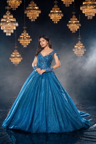 Woman in a blue evening gown beneath golden chandeliers
