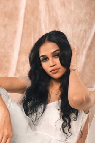 Woman with long dark hair against a soft peach backdrop