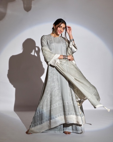 Woman modelling a flowing grey outfit in directional studio light