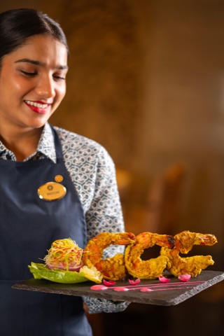 Restaurant server presenting a platter of golden fried seafood