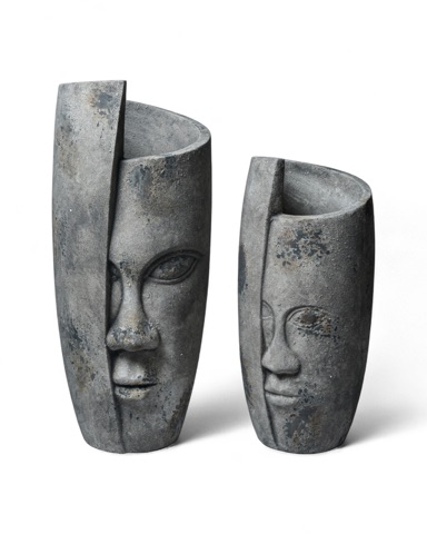 Two tall decorative vessels with sculpted faces
