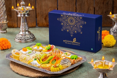 Blue gift box with a tray of sweets and lit decorative lamps