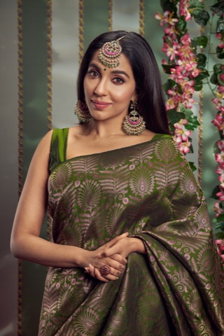Woman in a green sari wearing ornate jewellery