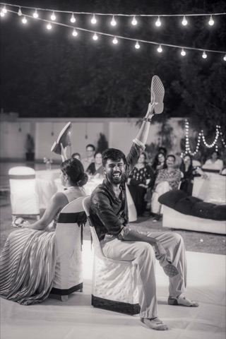 Black-and-white photograph of a couple dancing under string lights