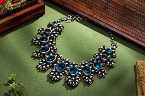 Blue-stone statement necklace on a green surface