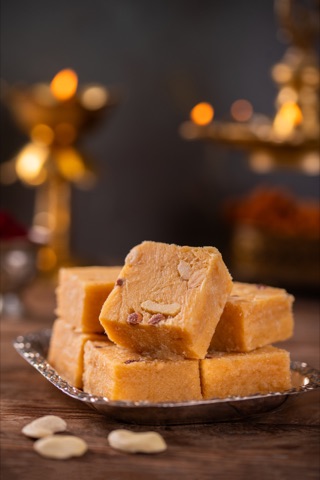Golden square sweets stacked on a plate in warm light