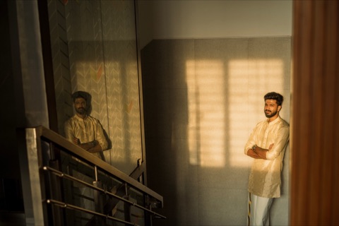 Man standing by a mirror in warm window light