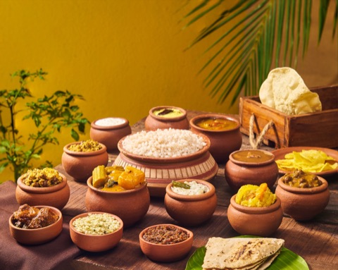 An assortment of rice, curries and accompaniments in clay pots