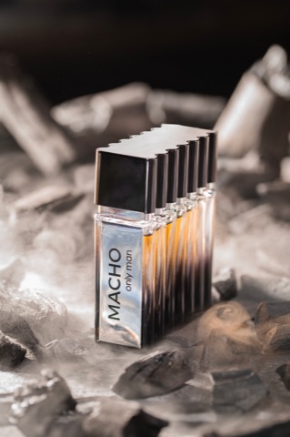 Rectangular perfume bottle standing among dark rocks
