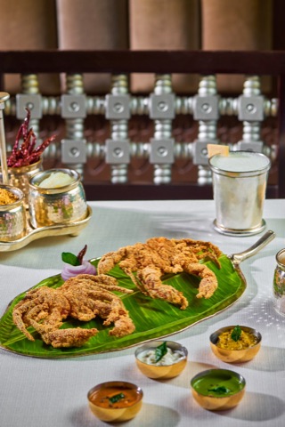Fried seafood on a green platter with small dipping sauces