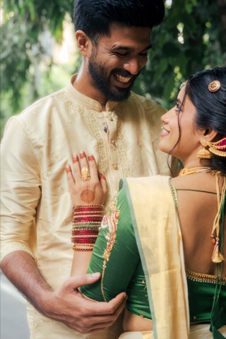 Smiling couple in cream and green wedding attire